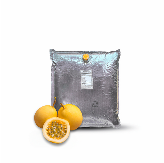Large gray bag with a label next to two passion fruits, one whole and one sliced, on a white background.